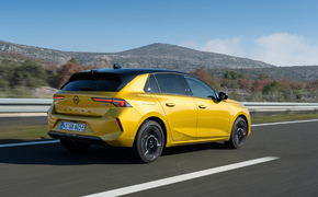 Opel AStra L fahrend von hinten aufgenommen, Astra ist in gelb lackiert.